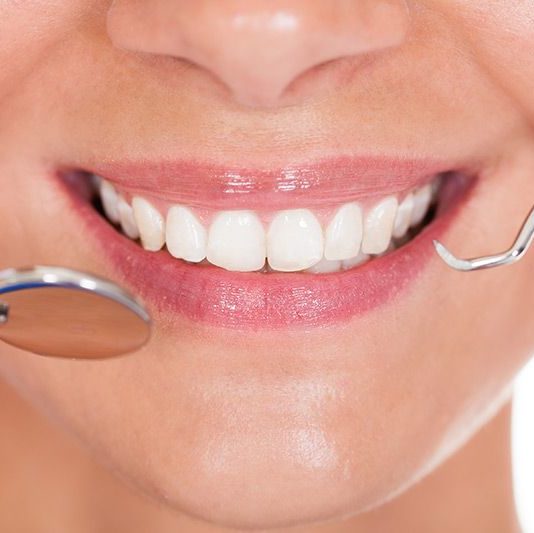 Woman's smile with dental tools
