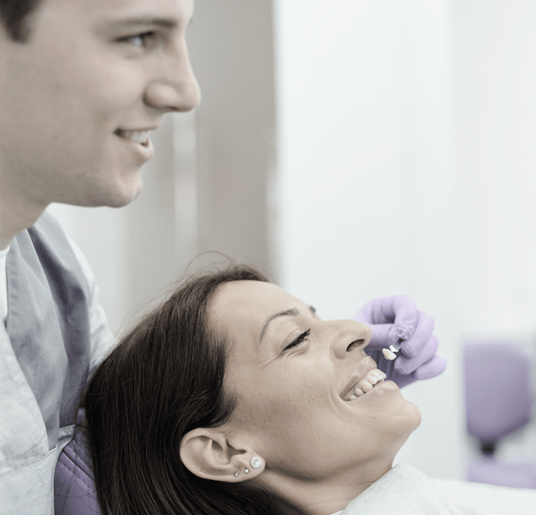 provider showing woman of model in front of her tooth